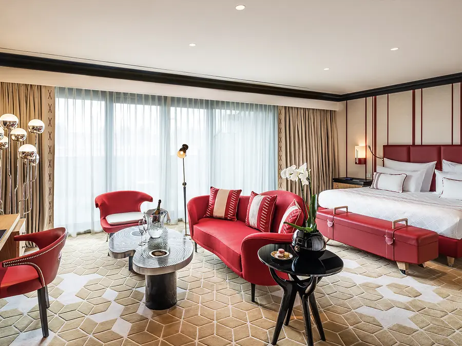 Hotelkamer met rode zitbanken en tapijt. Tapijt van Alfombras Peña.