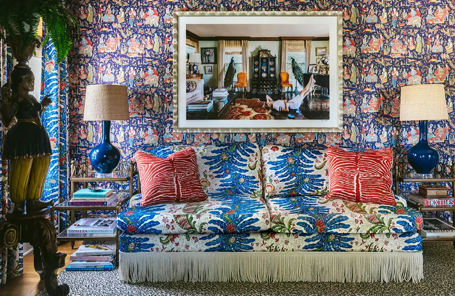 Salon met blauw bedrukte sofa en behang met dieren. Stoffen van Brunschwig & Fils.