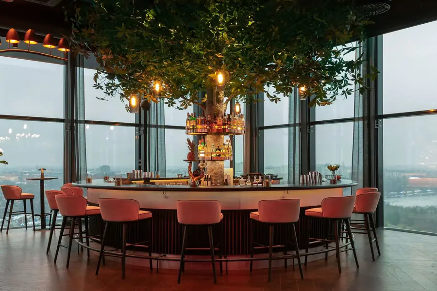 Restaurant met boom en rode stoelen. Stoffen van Création Baumann.