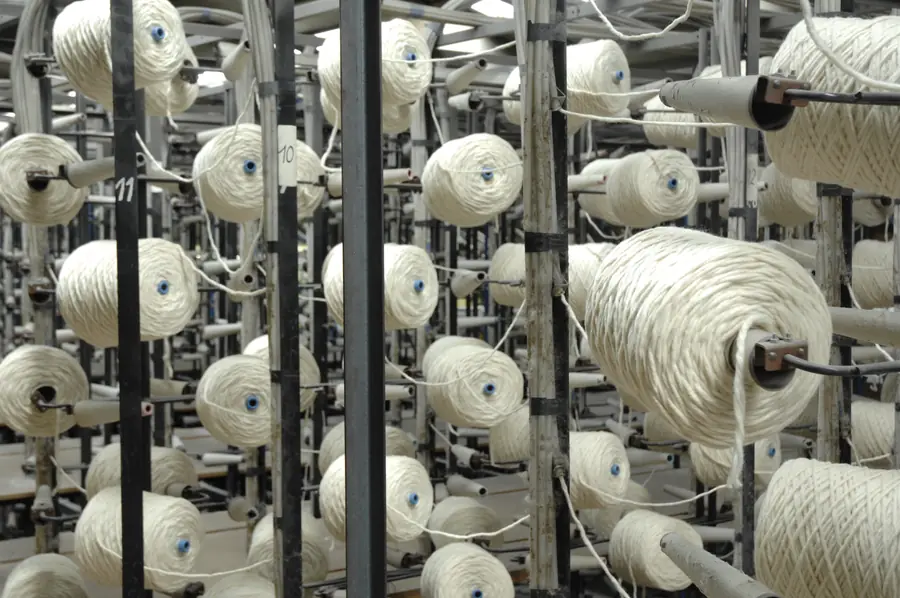 Garenrek van de tuftmachine in de weverij. Tapijt van Creatuft.