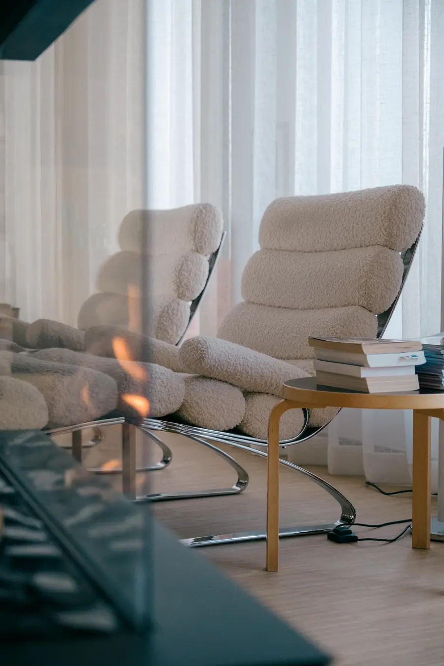 Zithoek met boucle fauteuils bij de haard. Stoffen van Diabolo.