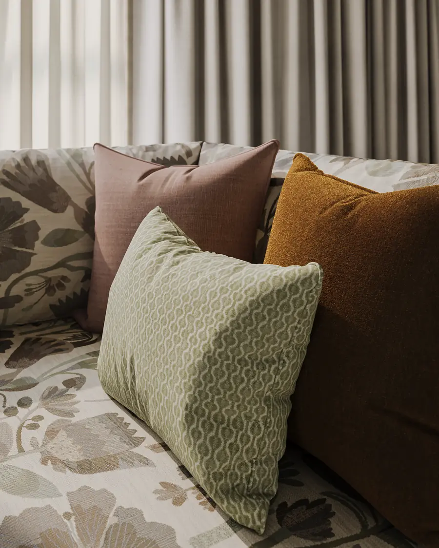 Kussens in groen, roze en oker op een sofa. Stoffen van George Spencer Design.