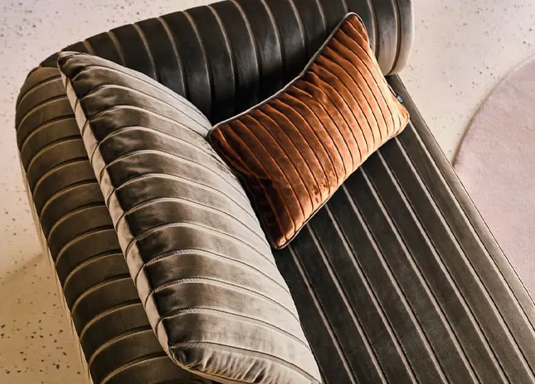 Velours kussens op een sofa. Stoffen van JAB.