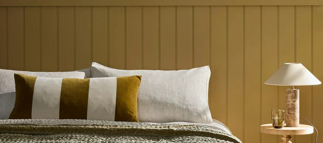 Slaapkamer met okergele lambrisering. Verf van Little Greene.