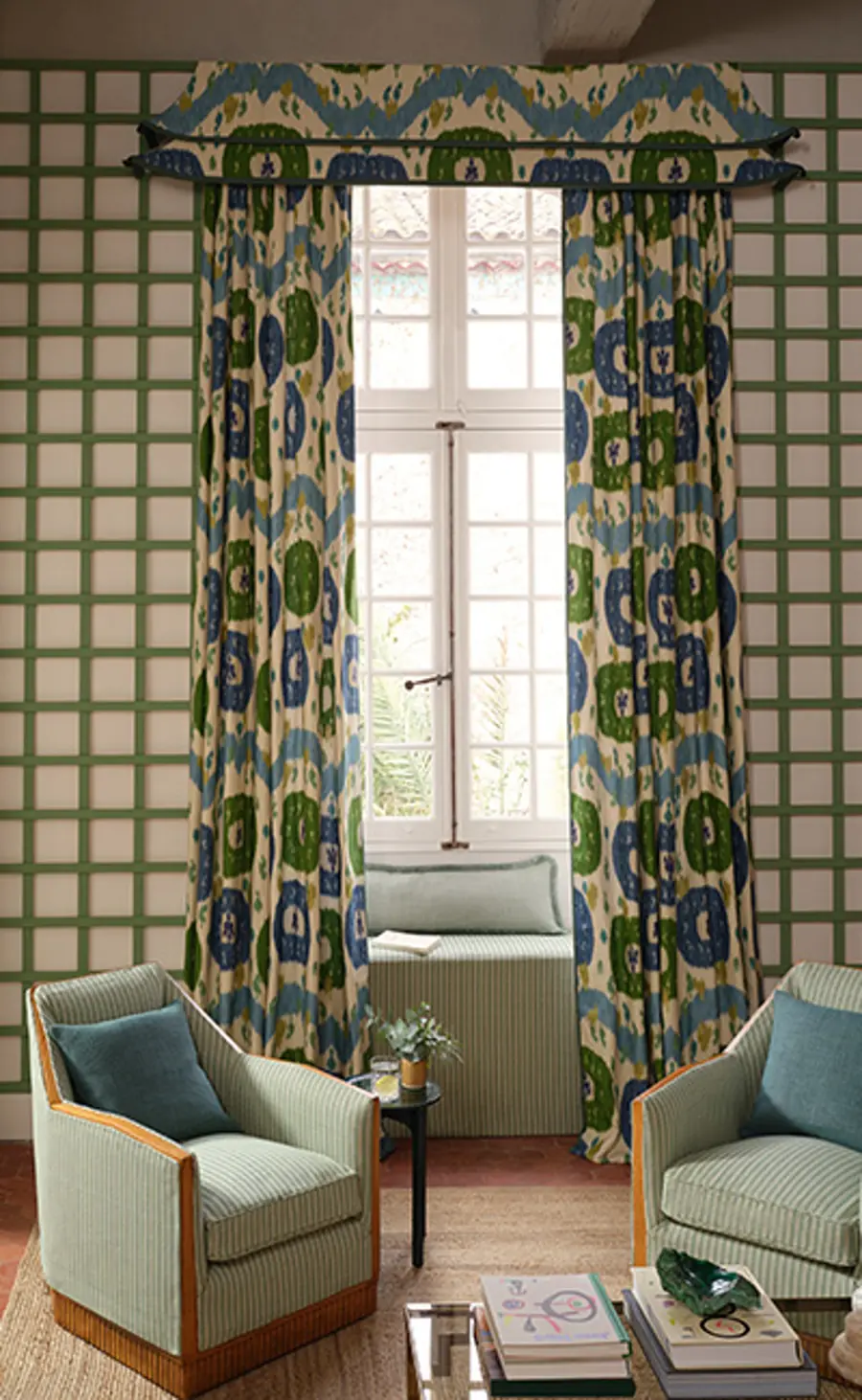 Salon met blauwgroene ikatgordijnen en groene ruitwand. Stoffen van Manuel Canovas.