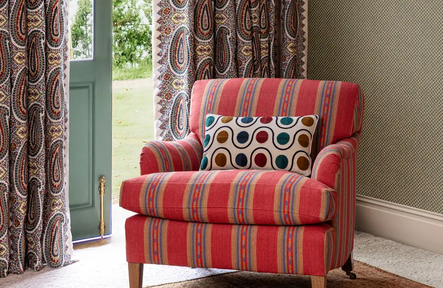 Rood gestreepte fauteuil bij een groene deur. Stoffen van Mulberry Home.