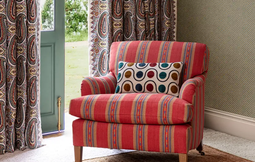 Rood gestreepte fauteuil bij paisleygordijnen. Stoffen van Mulberry Home.