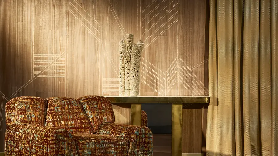 Eetkamer met gouden gordijnen en geometrisch behang. Stoffen van Nobilis.