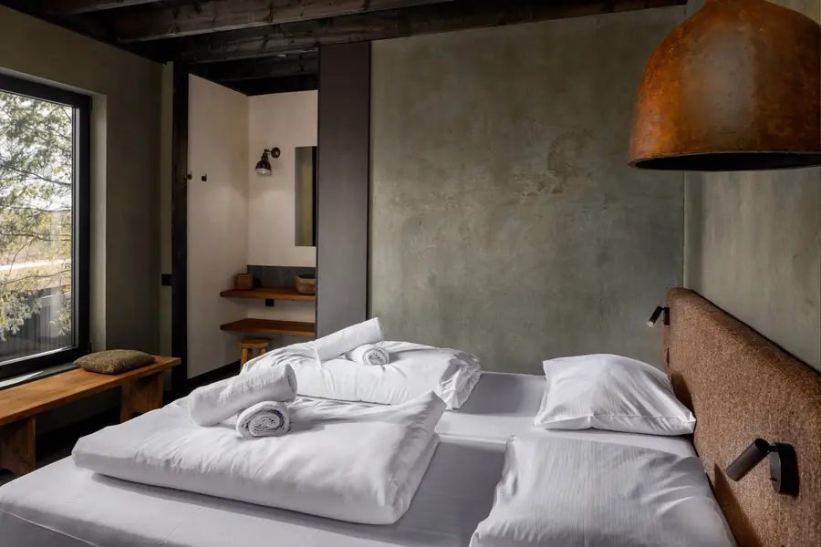 Slaapkamer met betonnen wanden. Meubelen van PR Living.