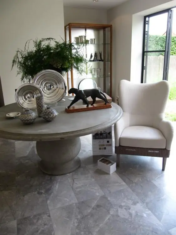 Zithoek met oorfauteuil en ronde tafel. Tapijt van Private Collection Rugs.