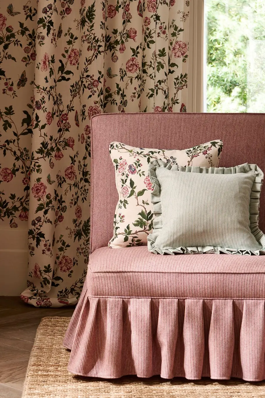 Roze fauteuil bij bloemengordijnen. Stoffen van Sanderson.