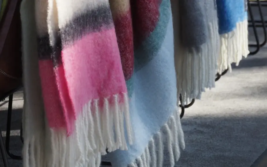 Gekleurde plaids aan een rail. Accessoires van Stackelbergs.