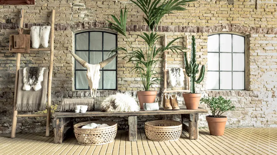Bakstenen kamer met schapenvachten en planten. Leder van Van Buren.