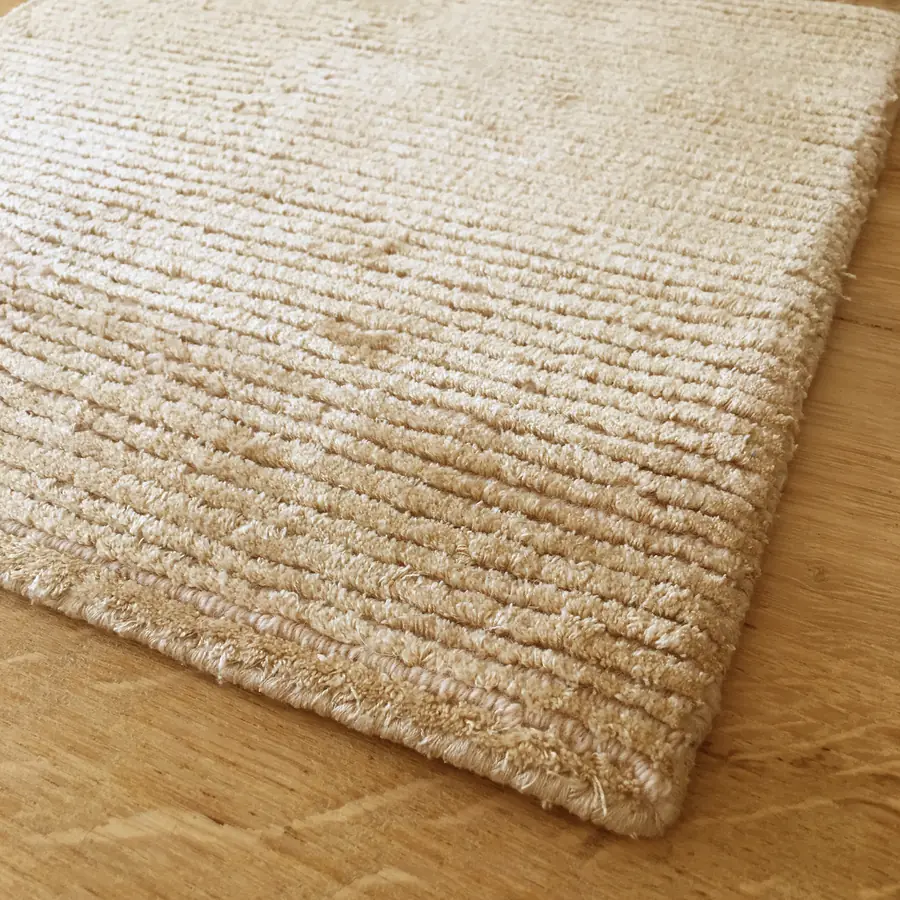 Tapijtrand op een houten vloer. Tapijt van Van Ghent.