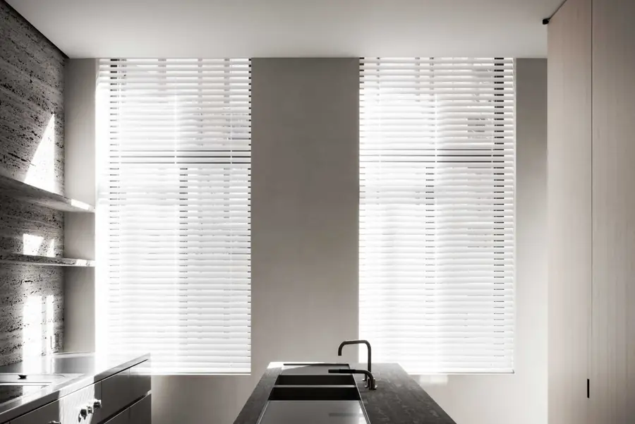 Keuken met witte houten jaloezieen in tegenlicht. Raamdecoratie van Vedelux.
