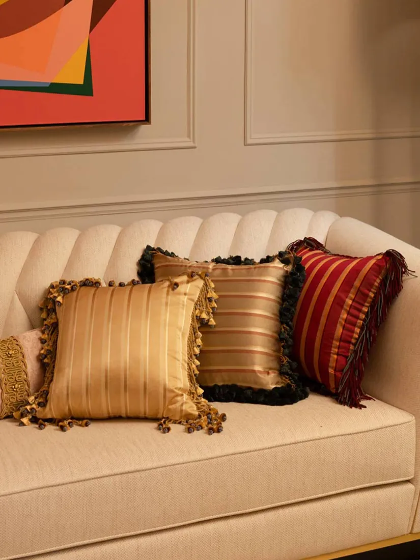 Sofa met kussens met franjes en strepen. Stoffen van Watts 1874.