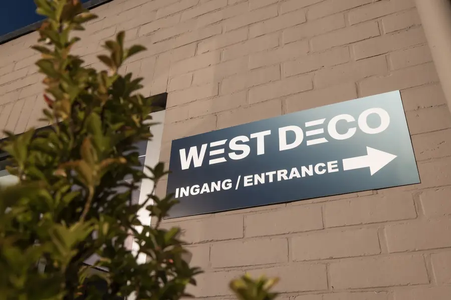 Het bord aan de ingang. Gordijnrails van Westdeco.