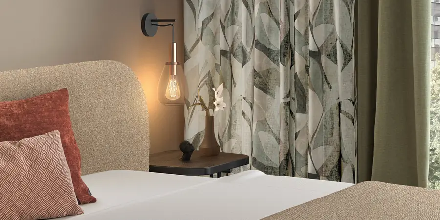 Slaapkamer met bedrukte gordijnen. Stoffen van Wind.